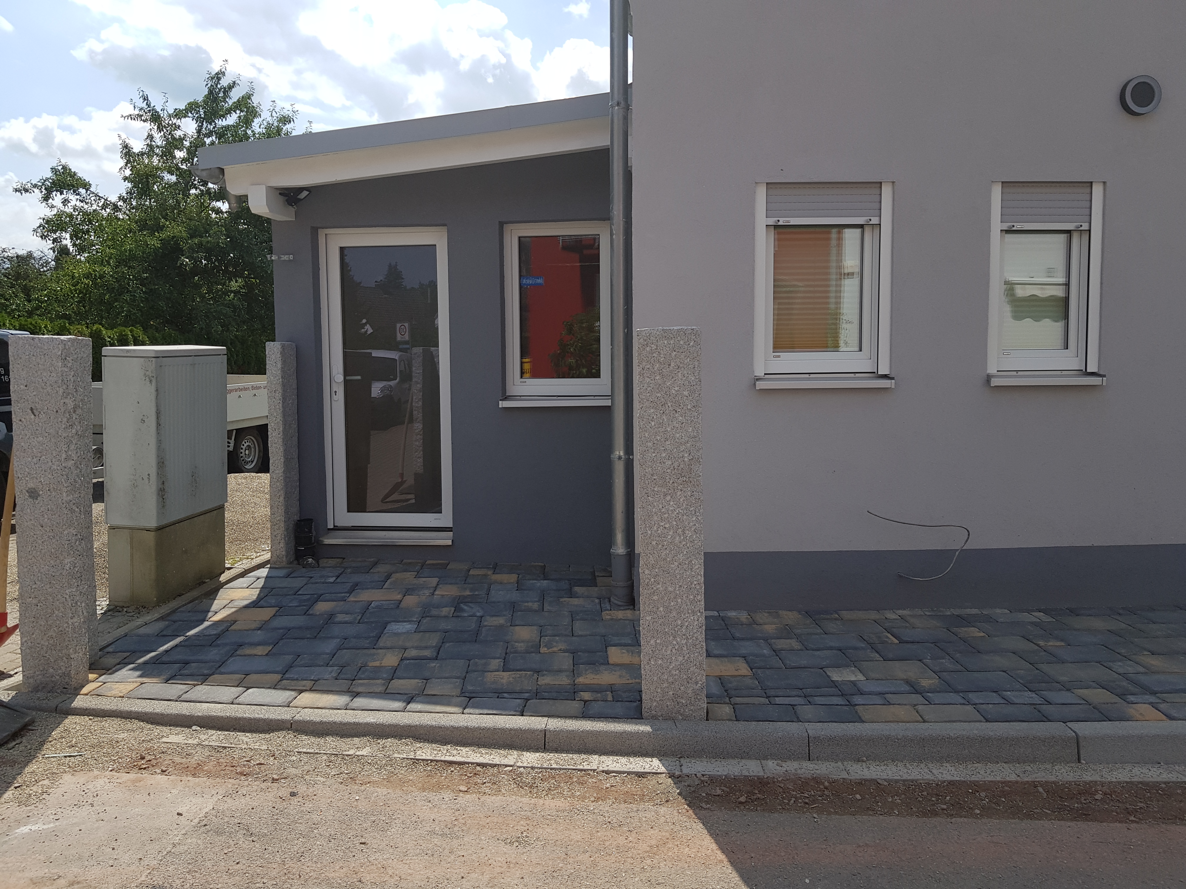 Außenanlage mit Unterbau, Pflaster und Granit Stele gestaltet